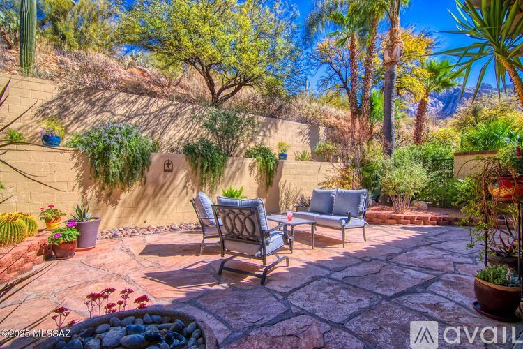 A patio with a table and chairs surrounded by plants.