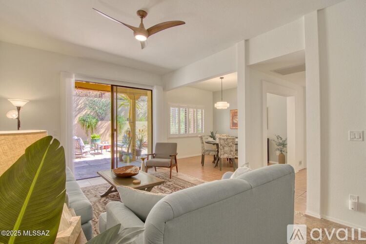 A living room with a grey couch and a ceiling fan.