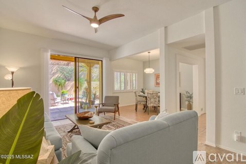 A living room with a grey couch and a ceiling fan.