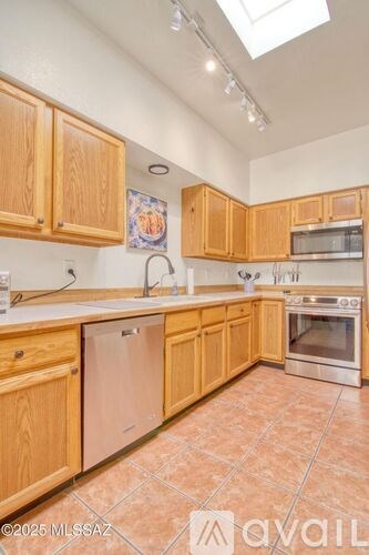A kitchen with wooden cabinets and tile flooring.