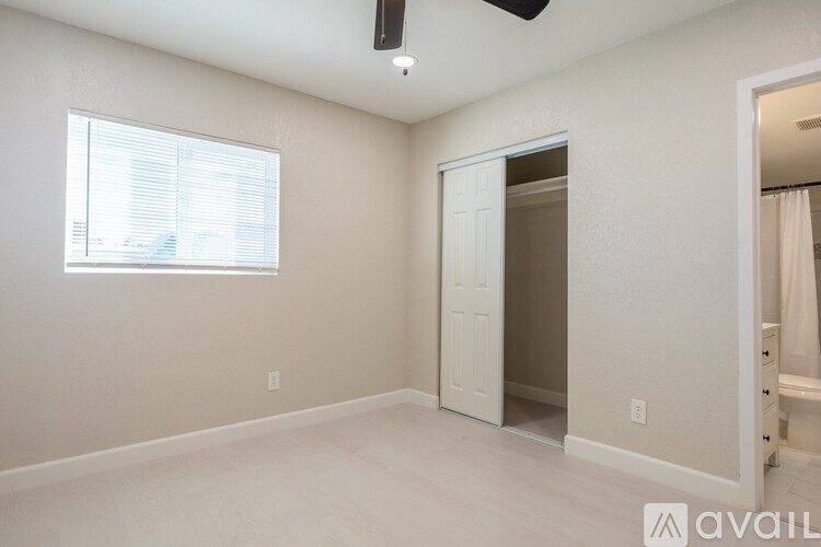 A room with a white door and a window with blinds.