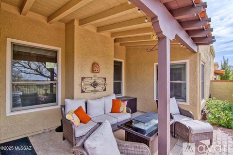 A patio with a table and chairs under a roof.