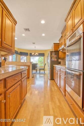 A kitchen with wooden cabinets and a refrigerator.