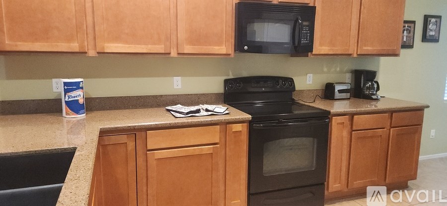 A kitchen with wooden cabinets and a black stove top oven.