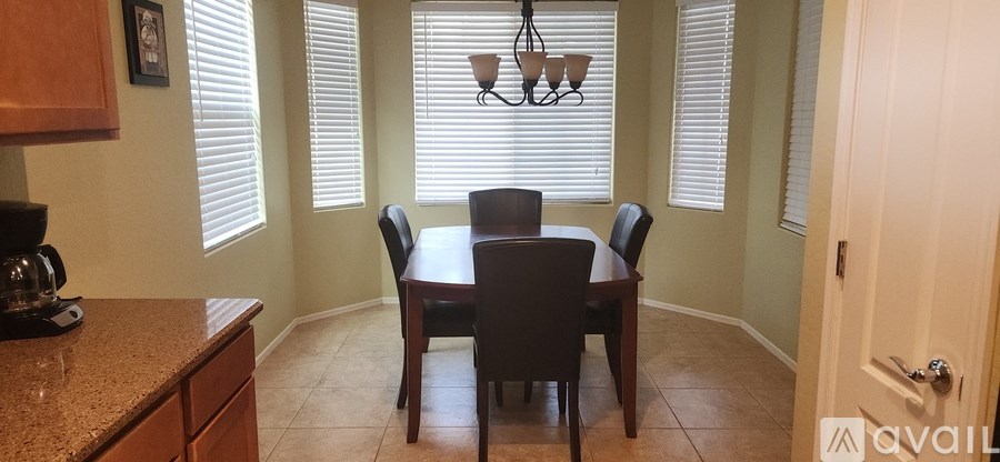 A dining room with a table and chairs.