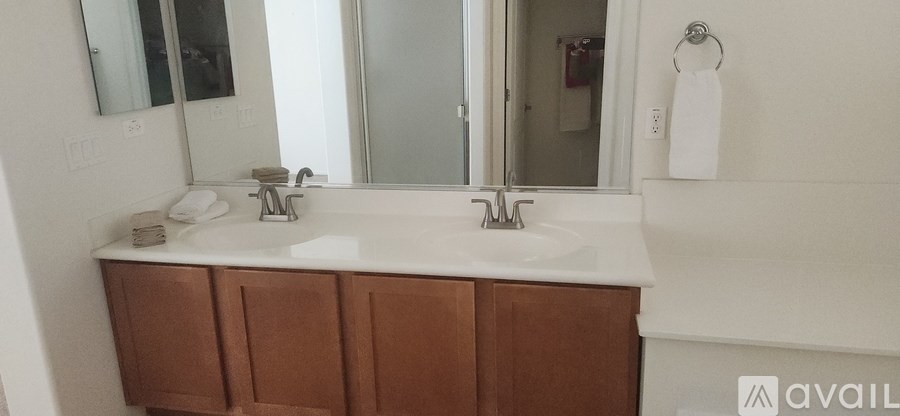 A bathroom with a white sink and brown cabinets.