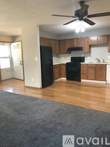 A kitchen with wooden cabinets and black appliances.