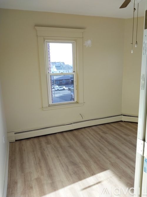 A room with a window and wooden flooring.