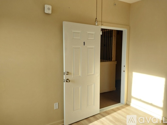A white door with a number 9 on it is open.