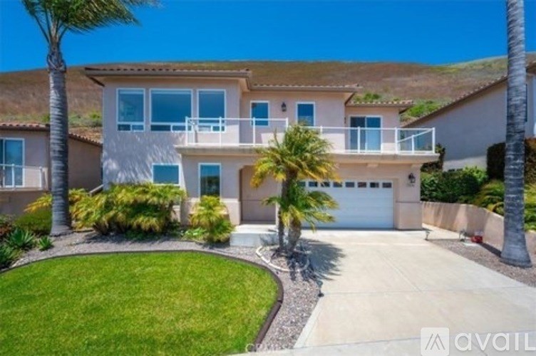 A house with a garage and palm trees in front.