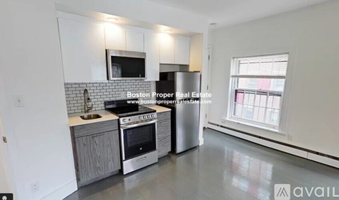 A kitchen with a stainless steel refrigerator and a stove top oven.