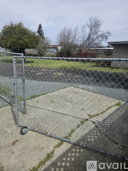 A metal shopping cart is parked on a concrete surface.