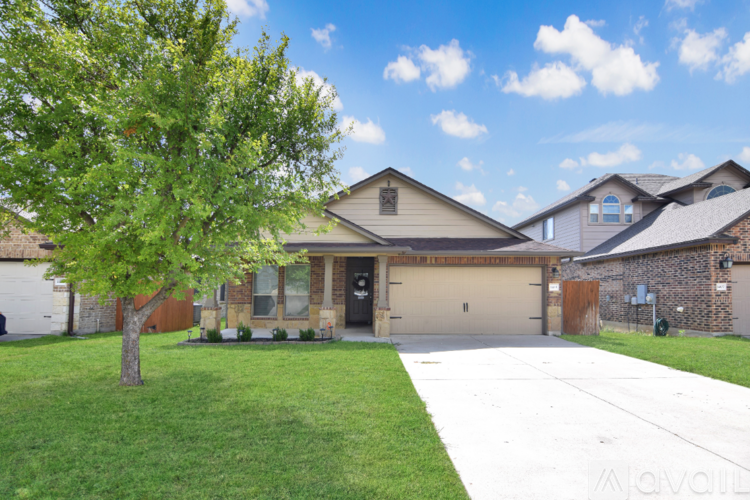 A house with a driveway and a tree in front.