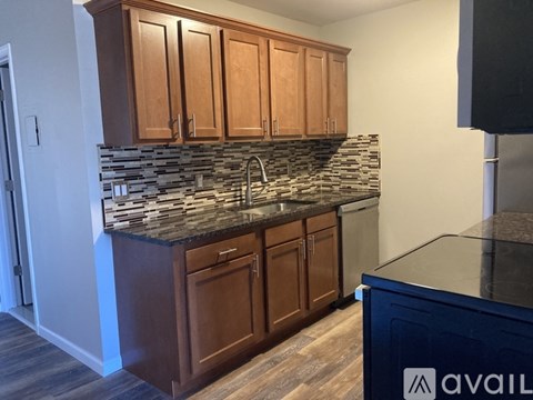 A kitchen with wooden cabinets and a stone backsplash.
