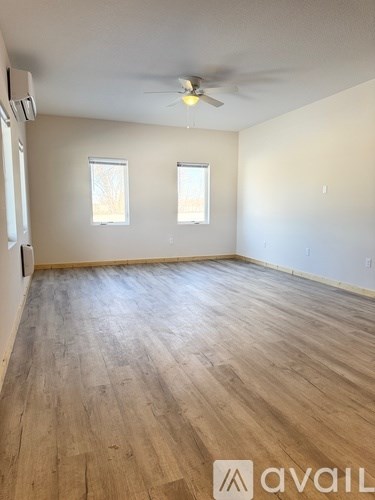 A room with wooden flooring and a ceiling fan.