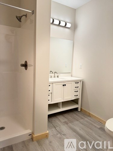 A bathroom with a white cabinet and a toilet.