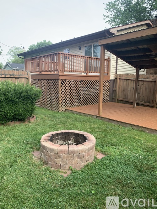 A backyard with a fire pit and a deck.