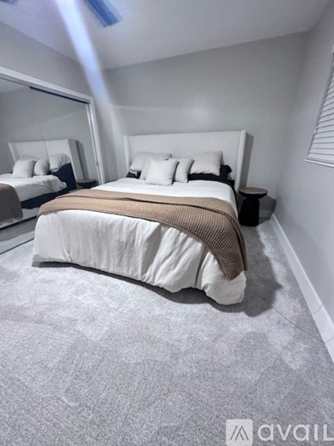 A bedroom with a large bed and a mirror on the wall.