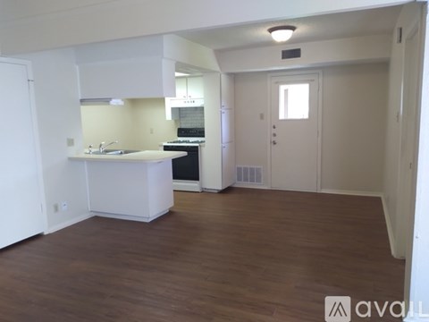 A kitchen with white cabinets and a white island with a sink.