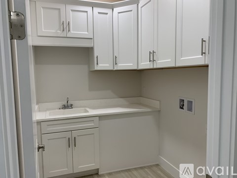 A white kitchen with a sink and cabinets.