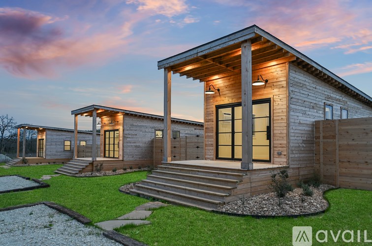 A modern house with a wooden exterior and glass doors is shown.
