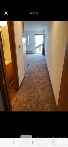 A long hallway with a carpeted floor and white walls.