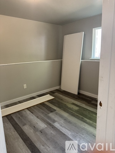 A room with a white door and a striped floor.
