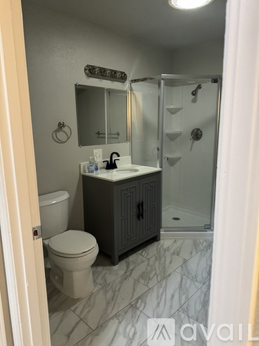 A bathroom with a toilet, sink, and shower.