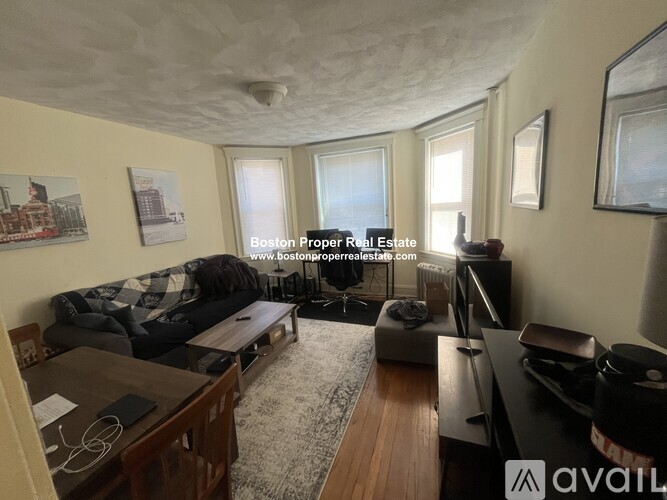 A living room with a couch, a coffee table, and a rug.