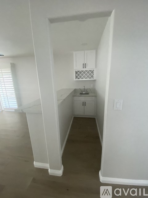 A kitchen area with white cabinets and a countertop.