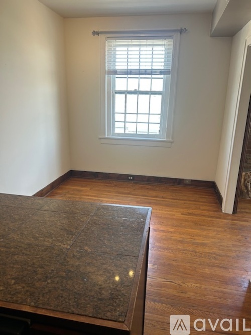 A room with a window and wooden floors.