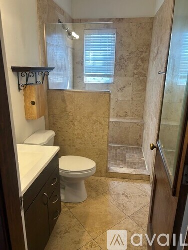 A bathroom with a toilet, sink, and walk-in shower.