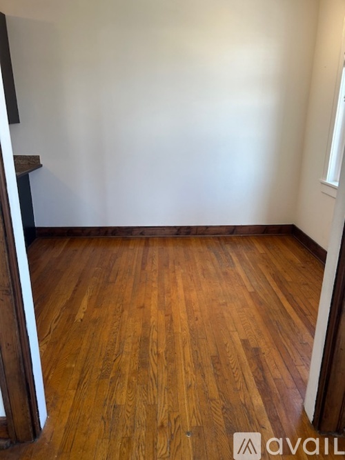 A room with wooden flooring and white walls.