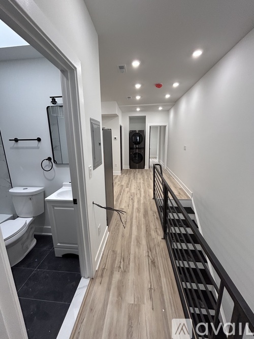 A hallway with a staircase and a toilet.