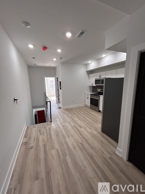 A spacious kitchen with a refrigerator, sink, and cabinets.