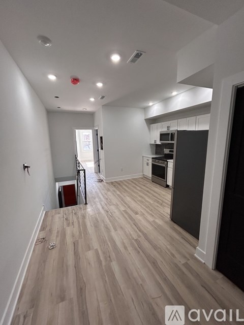 A spacious kitchen with a refrigerator, sink, and cabinets.