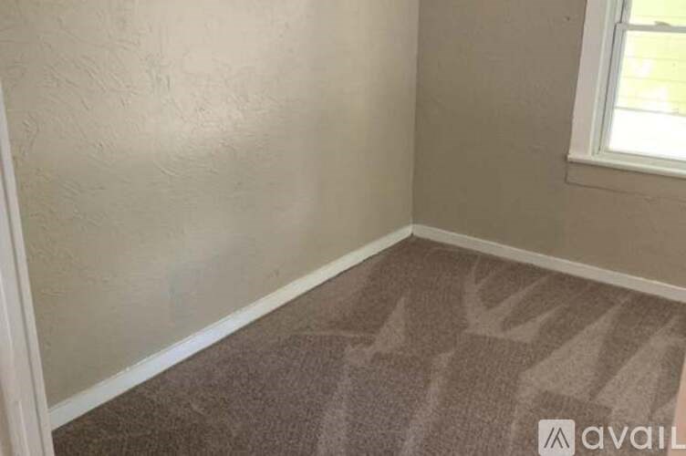 A room with a carpeted floor and a window.
