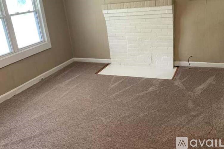 A room with a fireplace and a carpet.