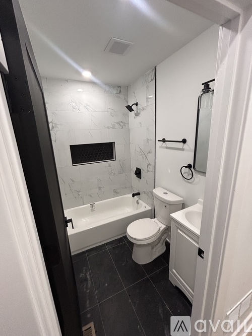 A bathroom with a toilet, sink, and bathtub.