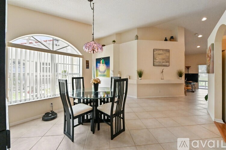 A dining room with a glass table and chairs.