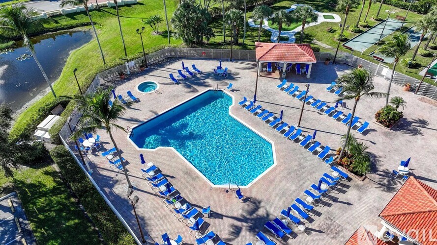 A large outdoor swimming pool surrounded by blue lounge chairs.