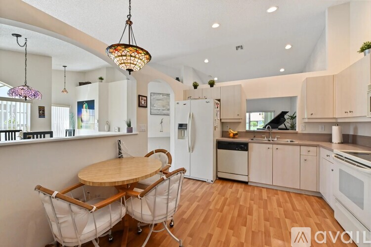 A kitchen with a round table and chairs.