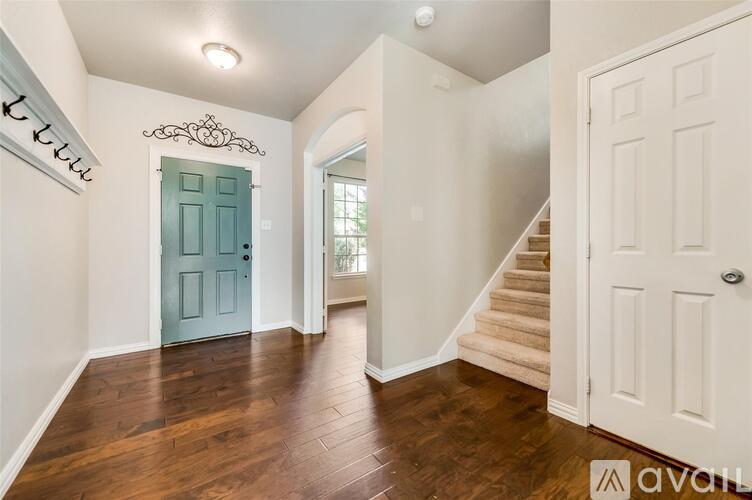 A hallway with a blue door and wooden floors.