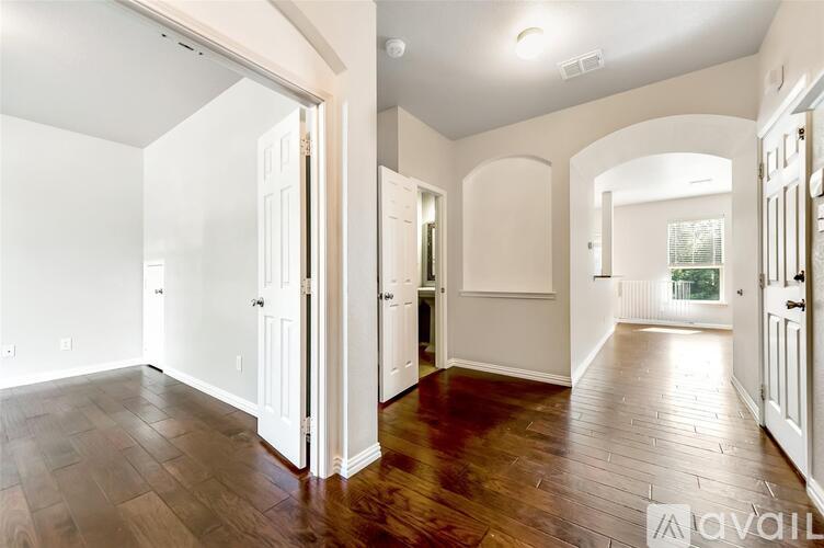 A spacious room with wooden floors and white walls.