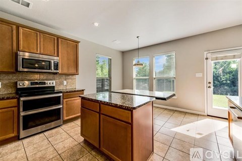 A kitchen with wooden cabinets and a granite countertop.