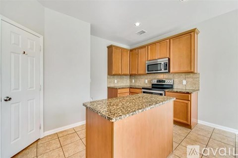 A kitchen with wooden cabinets and a granite countertop.