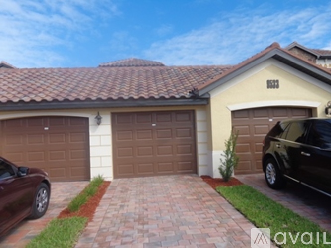 A house with a brown garage door and a brick driveway.