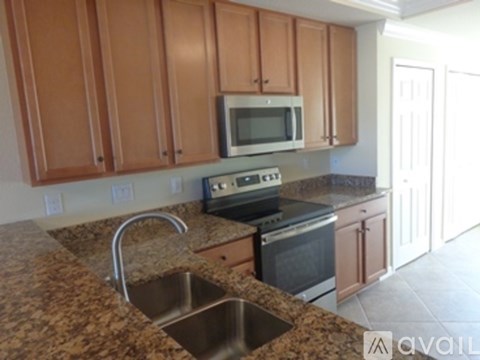 A kitchen with brown cabinets and granite countertops.
