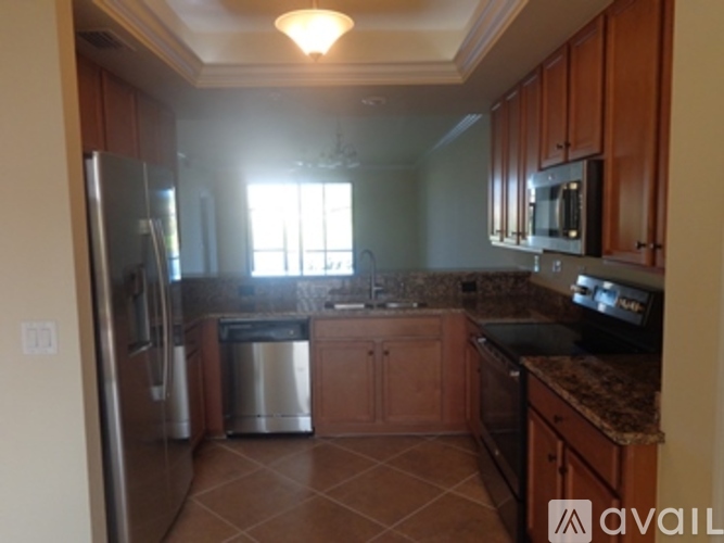 A kitchen with brown cabinets and a silver refrigerator.