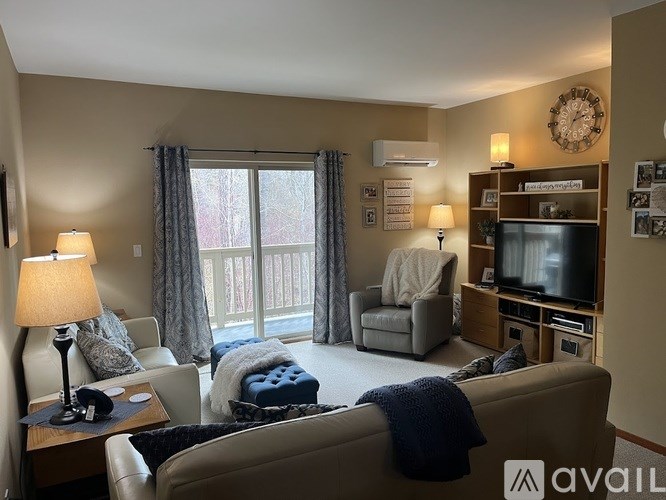 A living room with a couch, chair, and television.